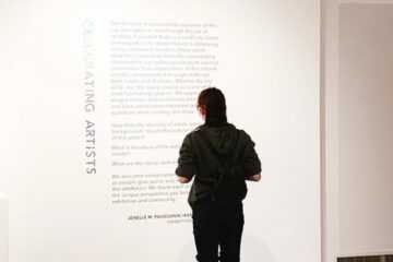 A teenager reads the a didactic at the Campbell River Art Gallery